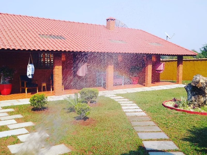 Conservação de jardins em Iaras: casa de tijolo com jardim, pisantes e aspersor, por Greg Garden Paisagismo