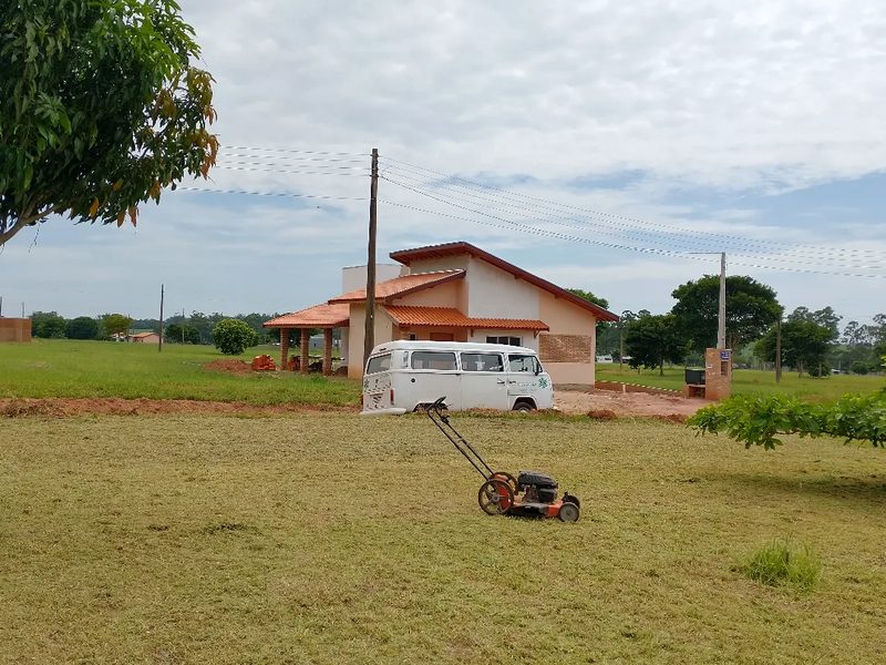 Manutenção de jardim em condomínio em Águas de Santa Bárbara: corte de grama em área grande, Kombi ao fundo, por Greg Garden Paisagismo